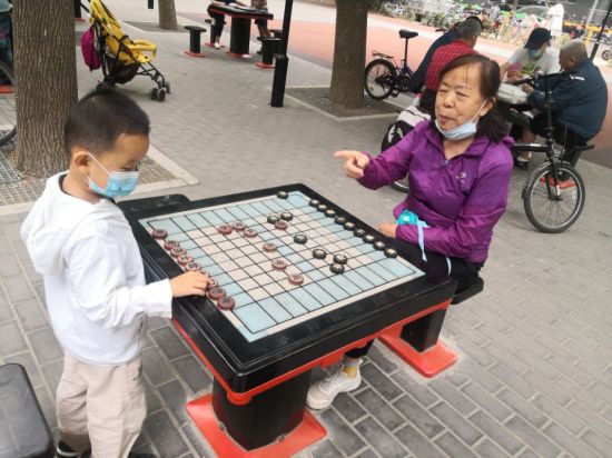 1402 孙子与奶奶下象棋 王青摄 - 副本.jpg